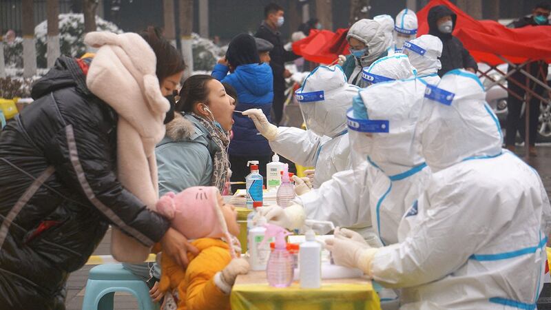 2022 年 1 月 5 日,河南省郑州市,身着防护服的医务人员在全市范围内进行核酸检测。(路透社)