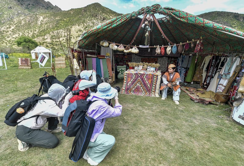 Tourists take photos at the Nomadic Culture Tourism Festival on June 15, 2024 in Urumqi,  Xinjiang Uyghur Autonomous Region of China.
