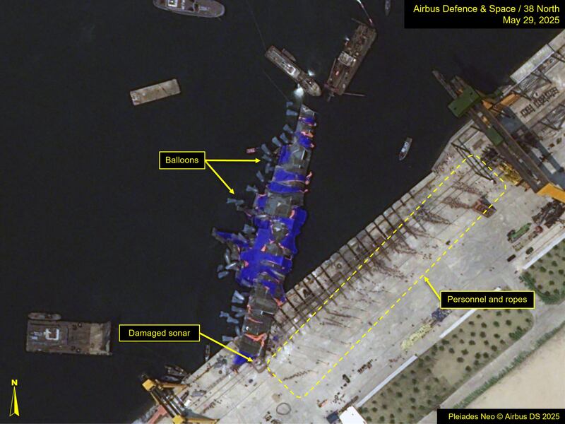 This May 29, 2025, image released by 38North.org, shows balloons and personnel utilized to lift the capsized North Korean destroyer back upright.