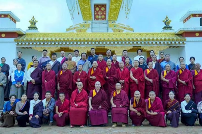 School teachers and staff pose for a group photo outside the Gangjong Sherig Norling school in a Tibetan area of western China's Qinghai province.