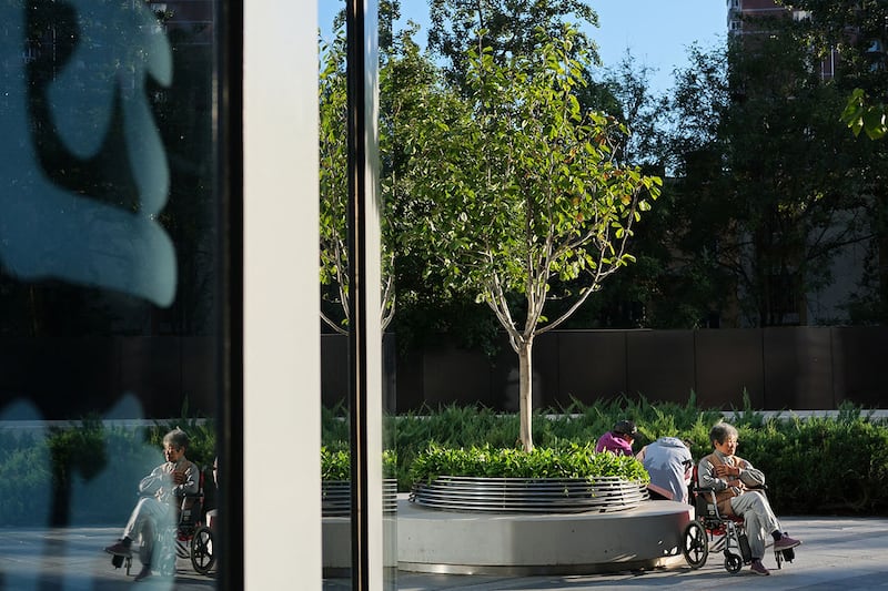 2024年10月7日,一位老妇人坐在北京购物中心的轮椅上。