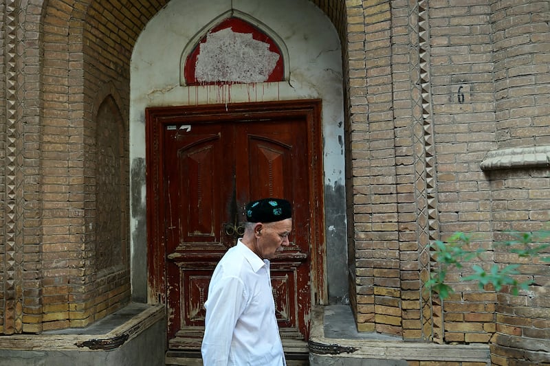 A Uyghur man walks past a closed mosque in Kashgar, in China's Xinjiang region, July 13, 2023.
