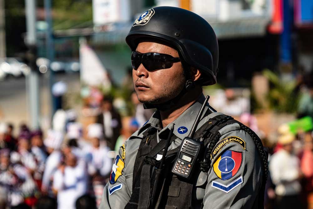 A policeman observes local protests against the Chinese backed Myitsone Dam. Photo: RFA